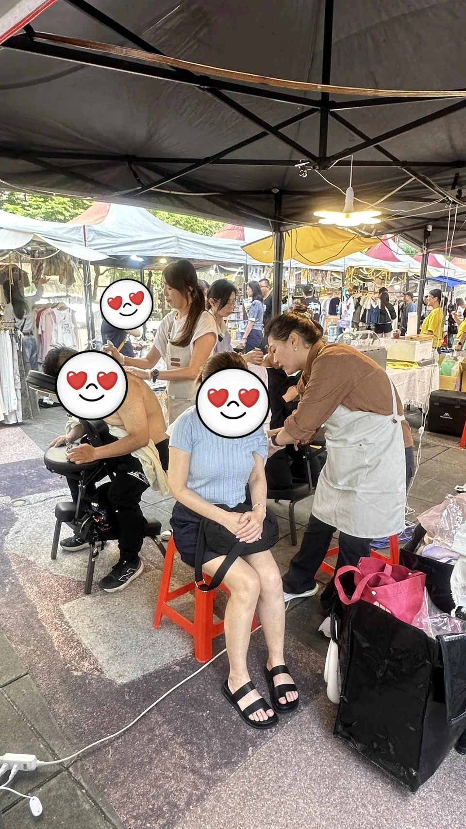 市集攤位上學員為坐著的客人做肩頸舒緩
