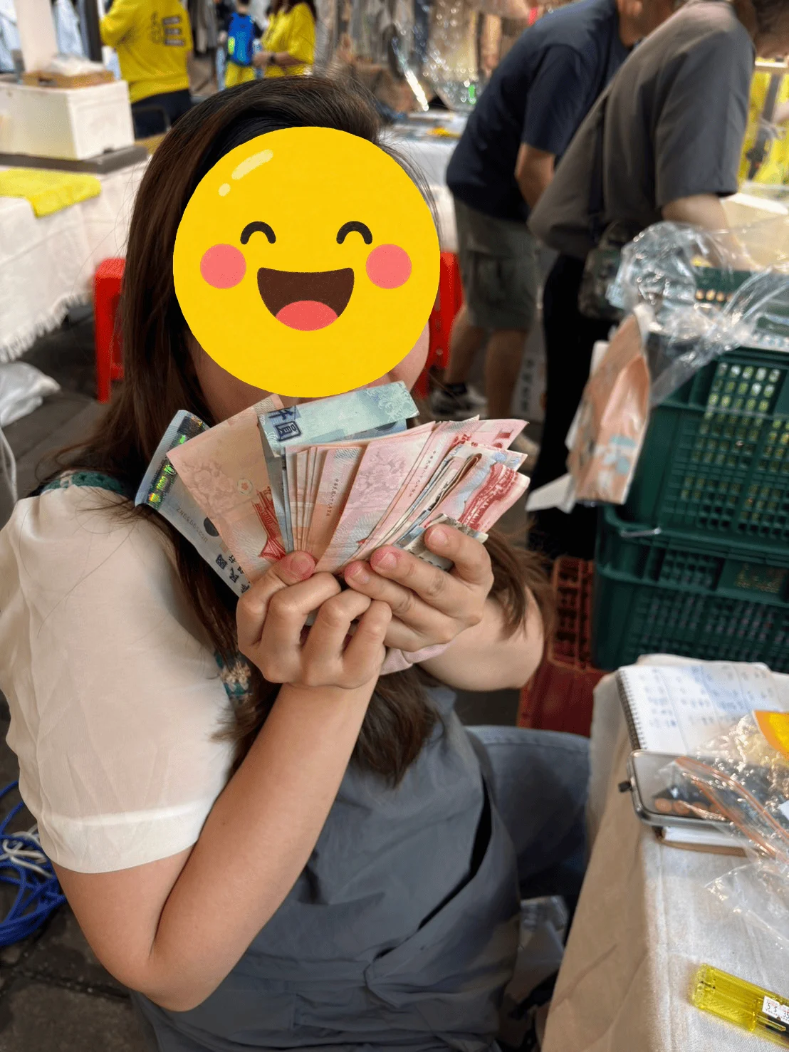 學員在市集收攤時手上握著一整疊現金